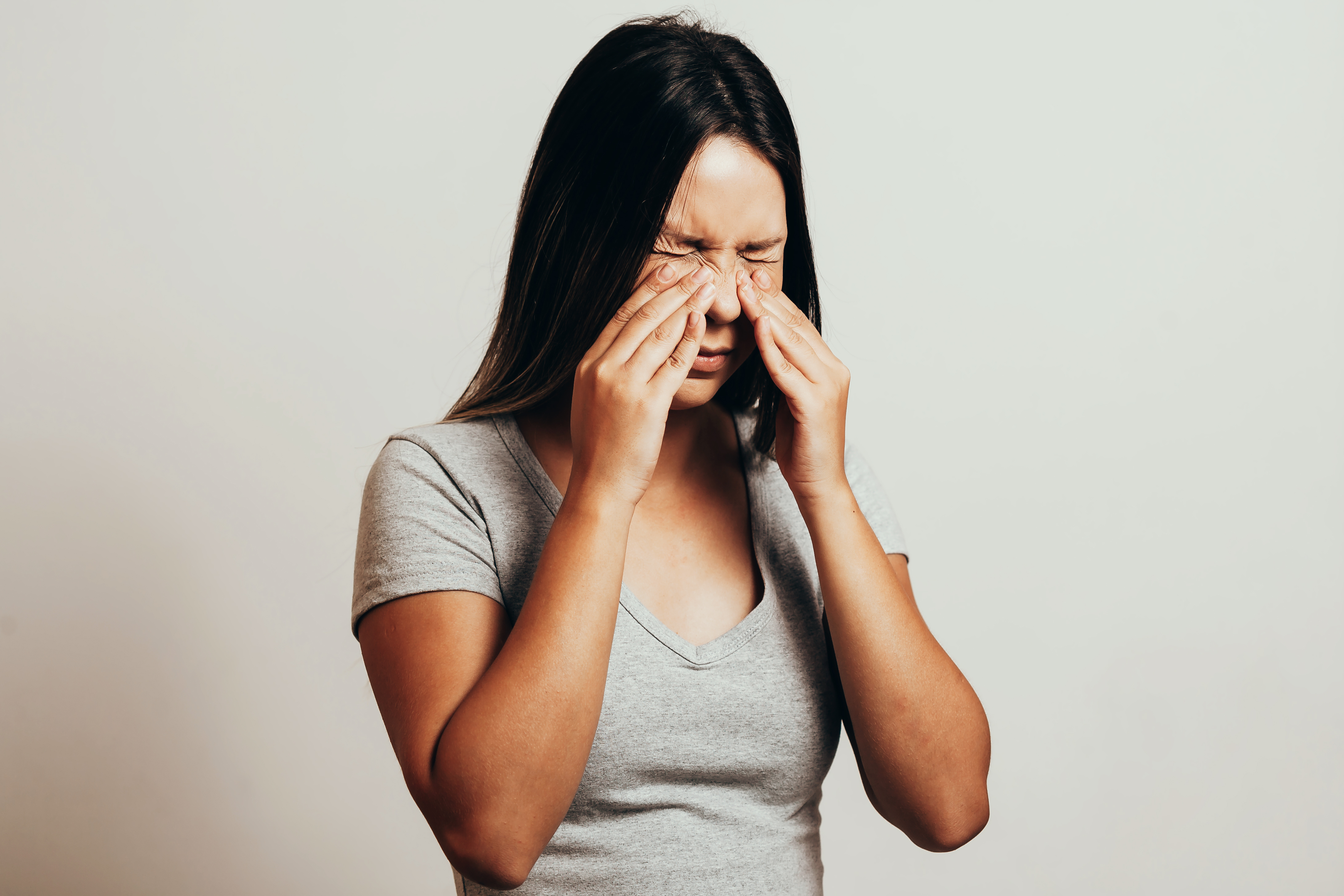 woman holding her nose sinusitis